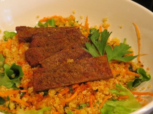 freshly grilled beef on top of a bed of quinoa, carrot shreds, various spices and a mix of greens from our garden!